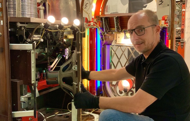 Museumstechniker an geöffneter Jukebox Wurlitzer 1015