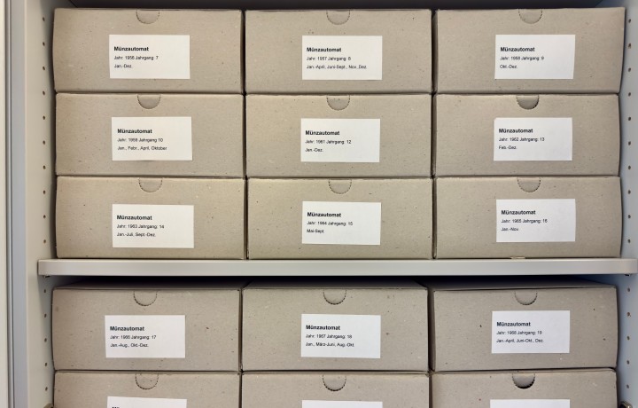 Geöffneter Archivschrank mit gestalten Archivkartons mit der Aufschrift 