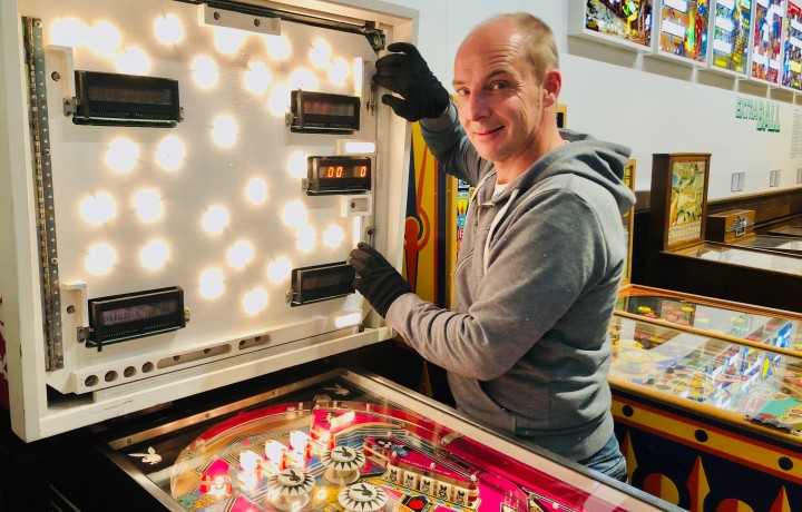 Museumstechniker Matthias Diekmann öffnet das Backpanel eines 70er-Jahre-Flippers.